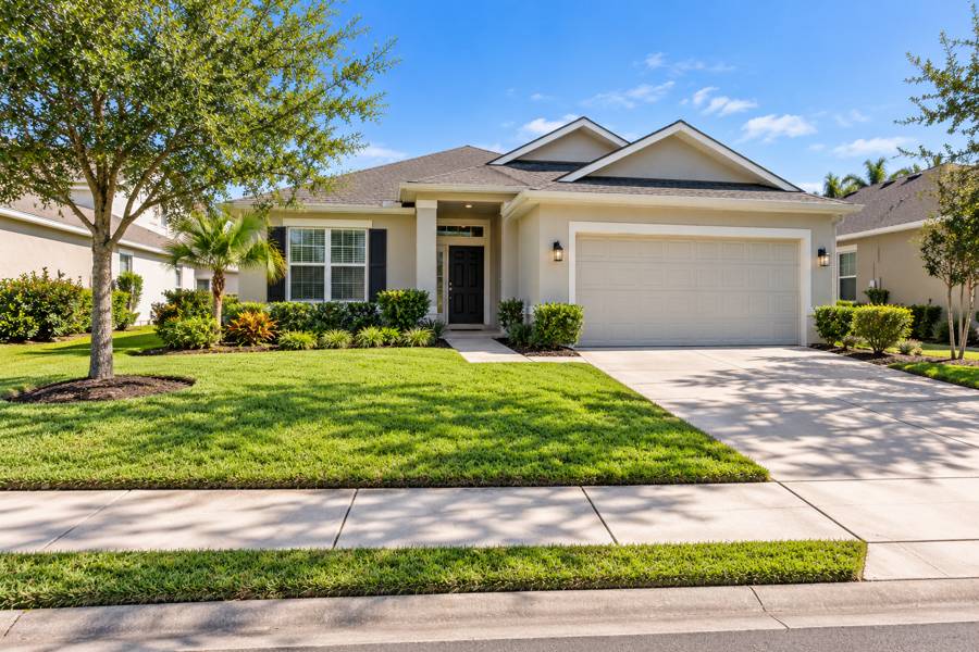 Single-story rental home with a tidy green lawn, edged walkway and landscaped beds in Florida daylight